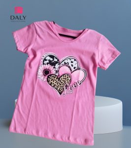 Polo infantil para niña de color rosa con estampado de corazones y flor en algodón.